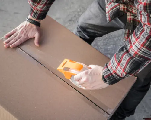 Mover Sealing a Box Before Transportation - Alpha packers and movers